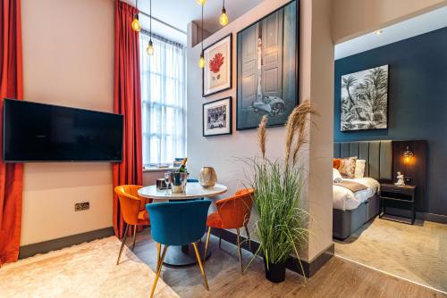a living room with a table and chairs and a bed at Duke Street Townhouse by EPIC in Liverpool