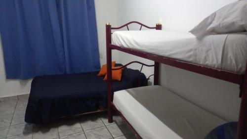 サンフアンにあるEl Cordobésの二段ベッド2台と青いカーテンが備わる客室です。