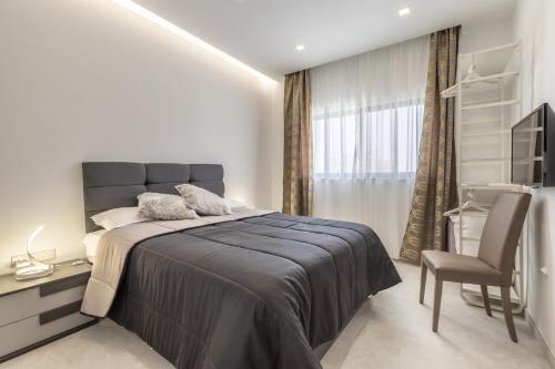 - une chambre avec un lit, un bureau et une chaise dans l'établissement St Julians Apartment, à San Ġiljan