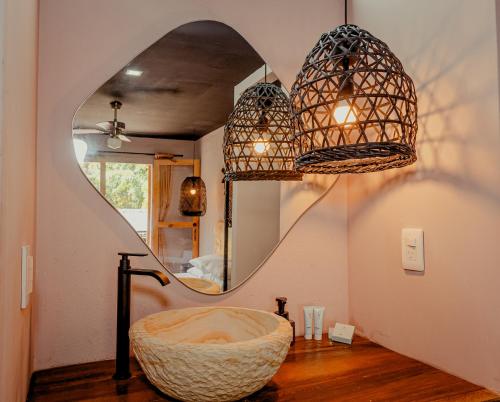 a bathroom with a large bowl sink and a mirror at Hotel Casa de Hadas in Minca
