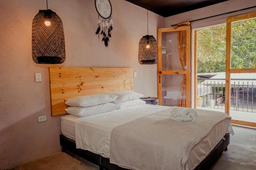 a bedroom with a bed and a window at Hotel Casa de Hadas in Minca