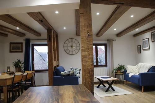 a living room with a table and blue chairs at La p'tite maison in Orschwihr