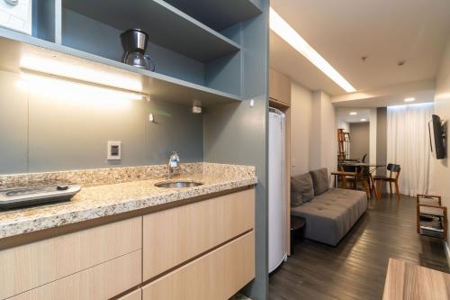uma cozinha com um lavatório e uma sala de estar em Apartamento em hotel 5 Estrelas Brasília - GMB0414 em Brasília