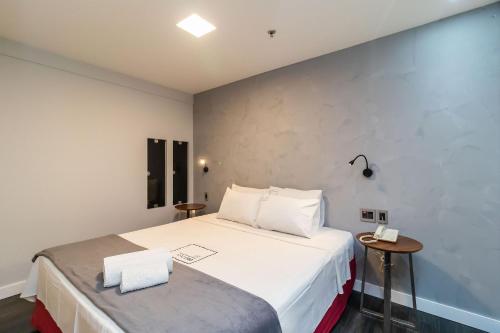 um quarto com uma grande cama branca e duas mesas em Apartamento em hotel 5 Estrelas Brasília - GMB0414 em Brasília