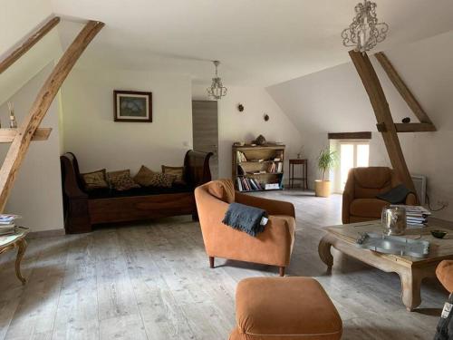 ein Wohnzimmer mit Sofa und Tisch in der Unterkunft Maison au cœur du Perche in Val-au-Perche