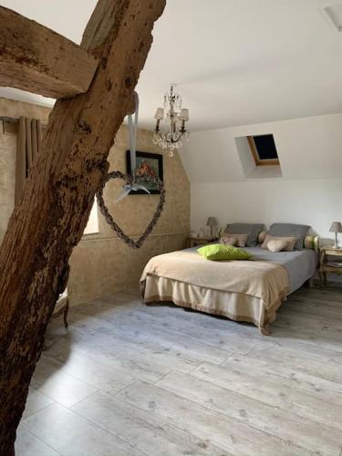 une chambre avec un grand lit dans une pièce dans l'établissement Maison au cœur du Perche, à Val-au-Perche