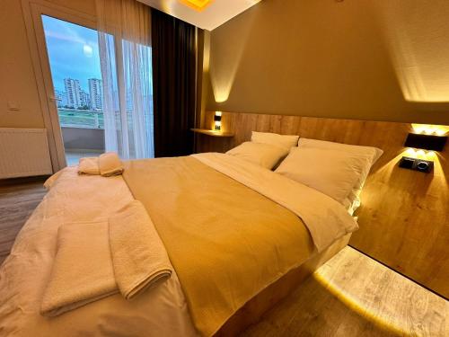 a large bed in a bedroom with a large window at SAYA LIFE KONAKLAMA in Mersin