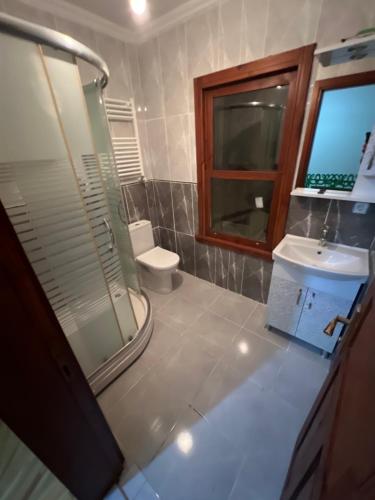 y baño con aseo, lavabo y ducha. en Lux sea view willas en Estambul