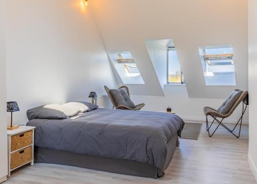 une chambre avec un lit et deux chaises dans l'établissement Maison de ville en bord de Seine à La Bouille, à La Bouille