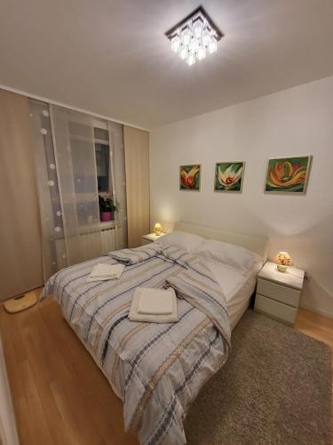 1 dormitorio con 1 cama grande y 2 mesitas de noche en Apartman Jarun lake, en Zagreb