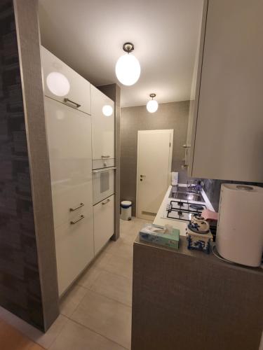 a kitchen with white cabinets and a stove top oven at Apartman Jarun lake lux in Zagreb