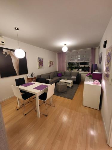 a living room with a table and chairs and a couch at Apartman Jarun lake lux in Zagreb