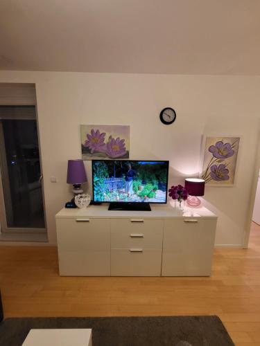 a living room with a tv on a white cabinet at Apartman Jarun lake lux in Zagreb