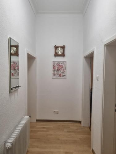 a hallway with a clock on a white wall at Exklusives Apartment nah S-Bahn in Bochum
