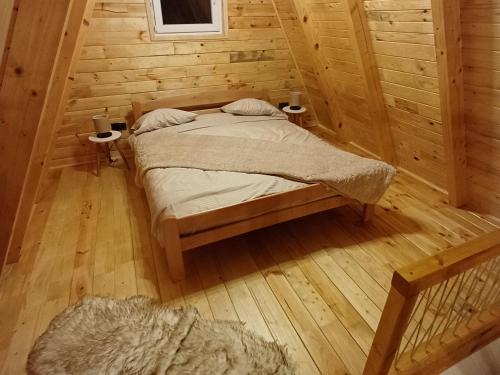 a bedroom with a bed in a wooden cabin at Mountain house Vojinovic Planinska kuća Vojinovic in Žabljak