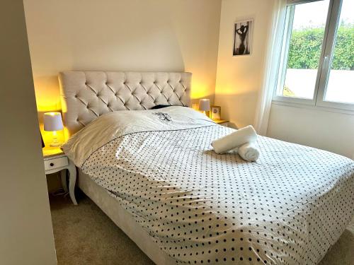 um quarto com uma cama grande e uma colcha branca em Agréable villa proche du Château de Carcassonne ! em Cazilhac