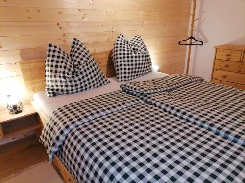 a bedroom with two beds with black and white sheets at Lärchenhaus ,,Unterer Brodl" in Kammersberg