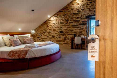 1 dormitorio con 1 cama en una habitación con una pared de piedra en Cherry Sculpture Hotel, en Paul