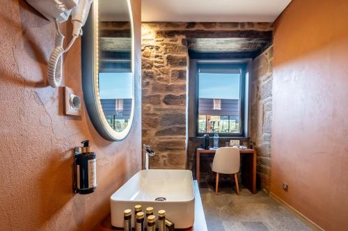 bagno con lavandino, scrivania e finestra di Cherry Sculpture Hotel a Paul