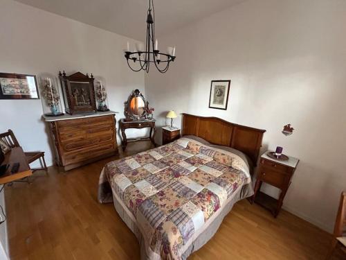 una camera con letto, cassettiera e orologio di La Porta di San Domenico a Sessa Aurunca