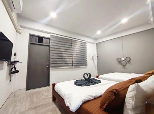 a bedroom with two beds and a flat screen tv at 106 MAIN STREET by ZamanJa Betong in Betong