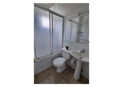 biała łazienka z toaletą i umywalką w obiekcie Departamento en arriendo condominio Playa Cau Cau en Horcon w mieście Puchuncaví