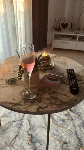 a table with a glass of wine and a remote control at Odore di Mare con Jacuzzi in Durrës