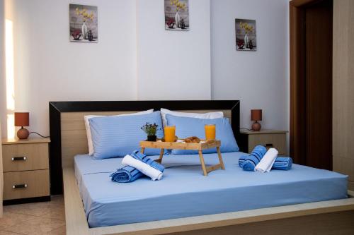 a bed with blue sheets and a table on it at Odore di Mare con Jacuzzi in Durrës