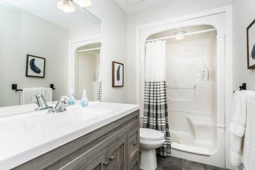 a white bathroom with a sink and a toilet at Our Special “Boutique” Quality Home in Old Towne in Niagara-on-the-Lake