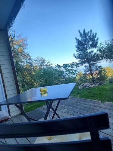 a picnic table sitting on a deck next to a bench at Charmante location Hauts d'Evian in Publier