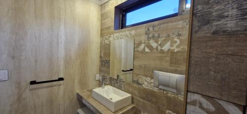 La salle de bains est pourvue d'un lavabo et d'une fenêtre. dans l'établissement Piso 3 frente al lago, centro Villa Carlos Paz pileta privada, à Villa Carlos Paz