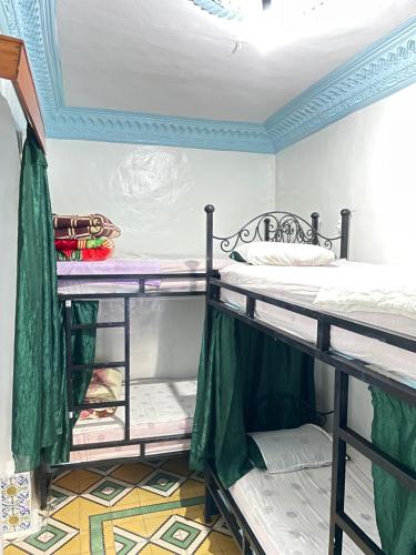 two bunk beds in a room with a ceiling at Hostel Aline in Chefchaouen
