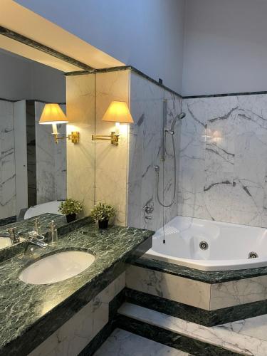 een badkamer met een bad, een wastafel en een douche bij CIVICO 16 in Chiaravalle