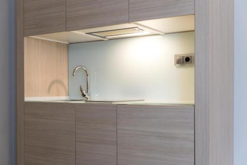 a kitchen with wooden cabinets and a sink at Tinas de Pechon in Pechón