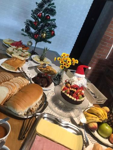 een tafel met eten en een kerstboom bij Pousada House Sol & Praia in Torres