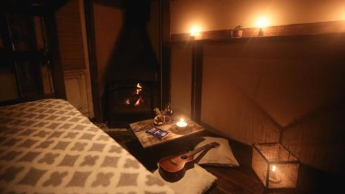 a guitar sitting on a bed in a room with a candle at Narakan Cabo Polonio in Cabo Polonio