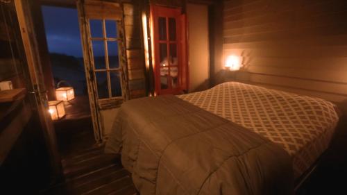 a bedroom with a bed next to a window at Narakan Cabo Polonio in Cabo Polonio