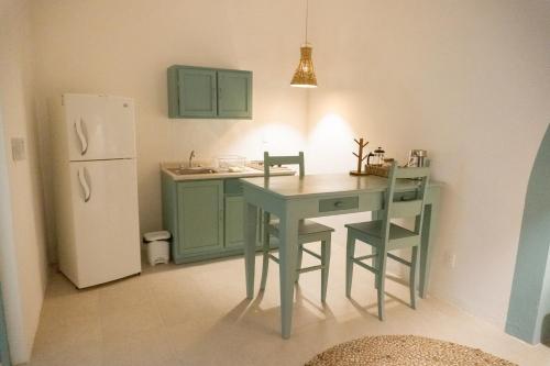 een kleine keuken met een tafel en een koelkast bij Casa Túnez in Campeche