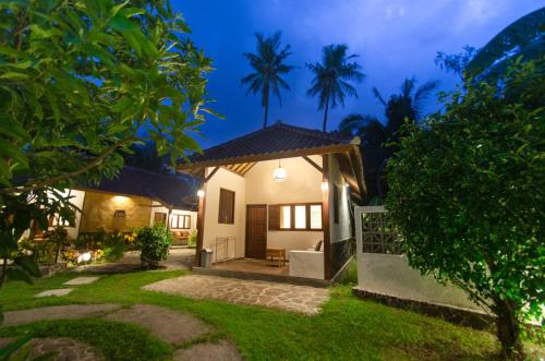 a house with a garden at night at Si Pitung Village in Gili Air