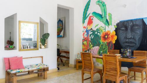 a living room with a table and chairs and a painting at HOSTEL LA CASA DE PETRA in Santa Marta