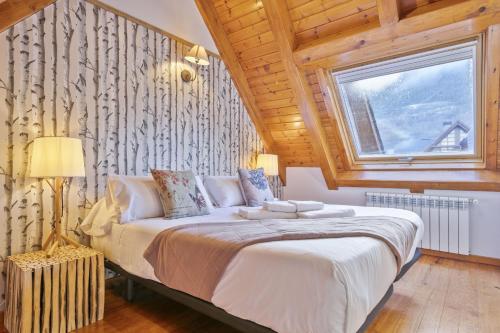 um quarto com uma cama grande e uma janela em Luderna - Dúplex des Neres em Vielha