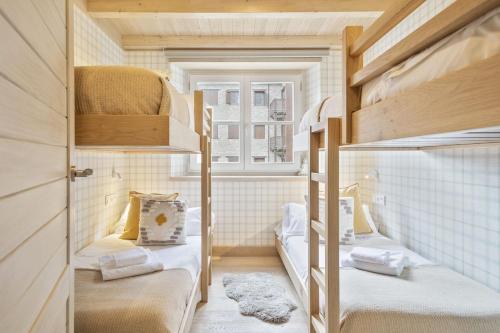 um pequeno quarto com 2 beliches e uma janela em Luderna - Apartamento Val de Ruda B22 Tuc Ermer em Baqueira-Beret