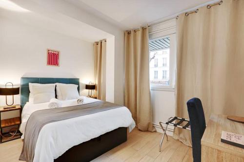 Un dormitorio con una cama grande y una ventana en Charming FLAT - Père Lachaise en París