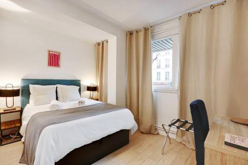 une chambre avec un grand lit et une fenêtre dans l'établissement Charming FLAT - Père Lachaise, à Paris