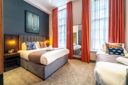 a hotel room with two beds and two windows at Duke Street Townhouse by EPIC in Liverpool