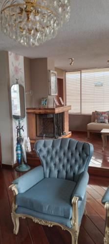 a living room with a blue couch and a chandelier at Pamplona apartment in Ambato