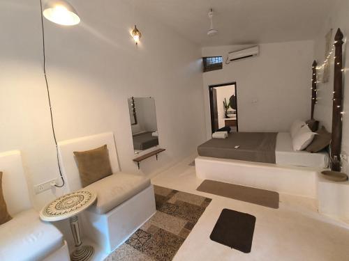 um quarto com uma cama, um sofá e uma televisão em Greek "Jungle Villa", Thalassa Road, Standing alone 3bhk villa with pool em Siolim