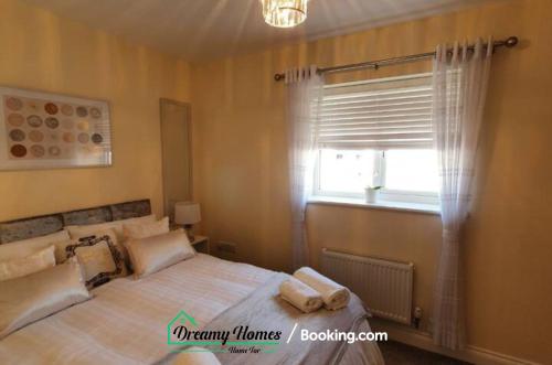 a bedroom with a bed with pillows and a window at Beach Braunton Spacious 3 Bed House By Dreamy Homes Short Lets & Serviced Accommodation Free Parking in Braunton