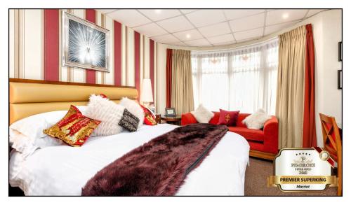 um quarto de hotel com uma cama e um sofá vermelho em Pembroke Bed & Breakfast em Blackpool