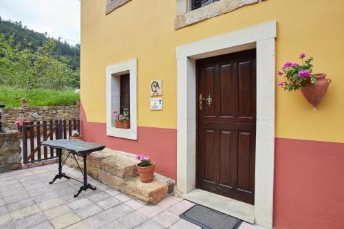 a building with a door and a table outside at Casa Rural Casa Capión in Villaviciosa